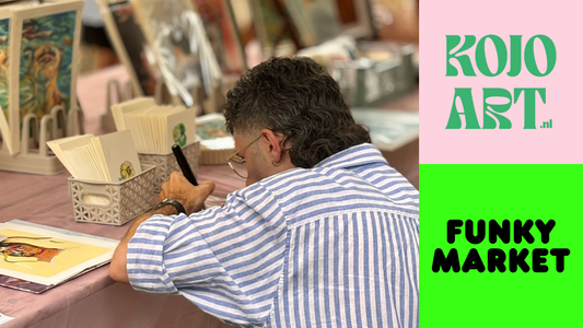 Kunstenaar van KOJO Art signeert kunstprints aan zijn kraam op de Funky Market in Tilburg, omringd door kleurrijke kunstwerken en kaarten.