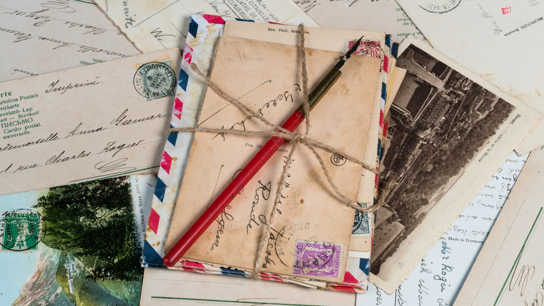 Creatieve snailmail voorbeelden met handgeschreven kaarten, decoratieve enveloppen en vintage postzegels op een houten tafel