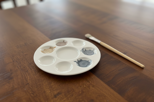 Mengpalet met gedempte aardse kleuren op een warme houten tafel — KOJO Art atelier Tilburg